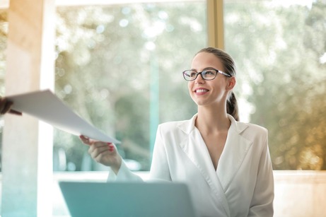 A professional in a bright office setting receives a document, symbolizing career opportunities with a Master of Legal Studies.